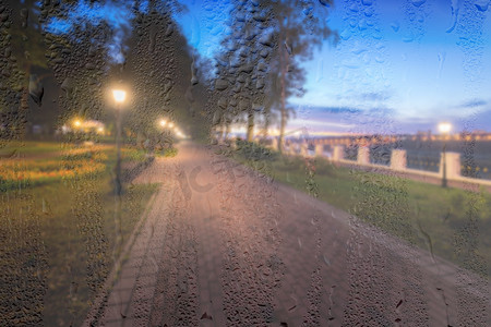 在 ni 的雨天、湿玻璃后面放着灯笼的散焦夜间公园