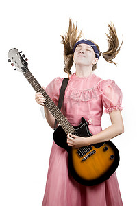 弹着摇滚吉他的年轻女孩演奏着狂热的音乐