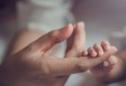 刚出生的婴儿握着妈妈的手。