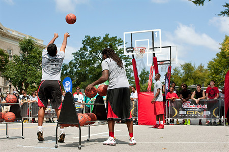年轻人在街头篮球比赛中投三分球