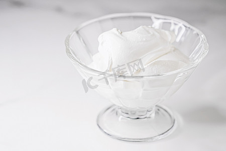 白色的生奶油放在玻璃碗里，质地柔滑