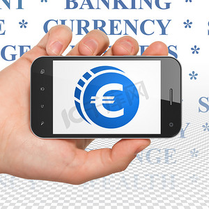 货币图案摄影照片_货币概念：手持有欧元硬币的智能手机上显示