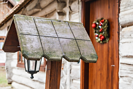 圣诞花环摄影照片_木屋门上的圣诞花环