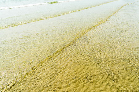 沙滩上透明的水波纹波浪轨迹