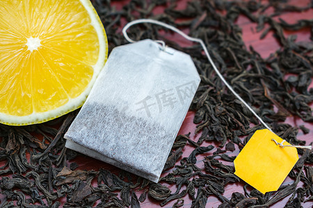 红茶叶上贴着黄色标签和新鲜柠檬的茶袋