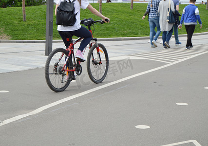 夏天，背着背包骑自行车的女孩在公园里骑行