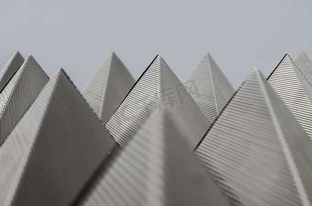 纳瓦尔灰色天空上的对称、金属、金字塔图案