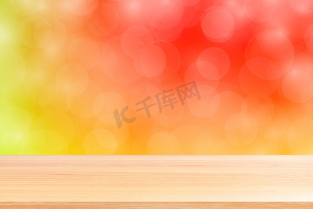 模糊的散景柔和红色渐变背景上的空木桌地板，红色散景彩色浅色上的木板空，用于横幅广告产品的彩色散景灯渐变柔和