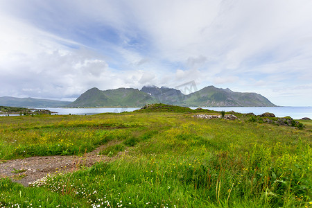 美丽的斯堪的纳维亚风景，有草地、山脉和村庄。