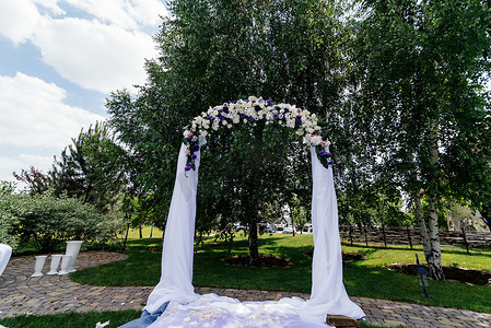 桦树附近有鲜花和白布的婚礼拱门