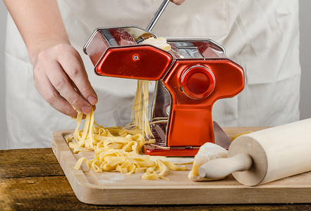 研磨加工摄影照片_厨师生产面食-意大利面食研磨机