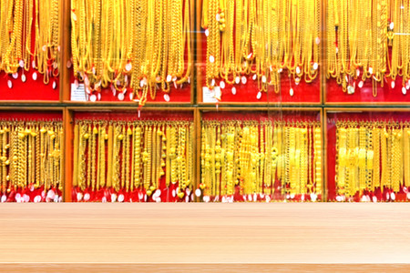 模糊的金色背景上的木板模糊，面板金店珠宝店的空木桌地板为卖家推荐产品和黄金展示柜，木桌板空的前金店墙