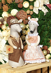 红金大气鼠年摄影照片_一对装饰玩具老鼠在鼠年的前夕在新年树的背景下穿着喜庆的衣服。