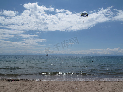 企业海面摄影照片_跳伞者在海面上的天空