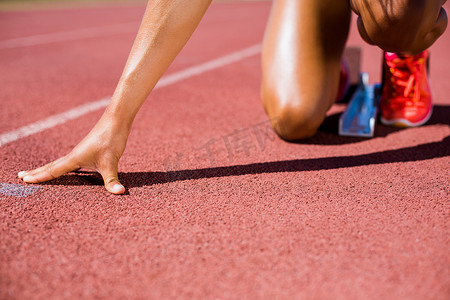 女运动员准备在跑道上奔跑