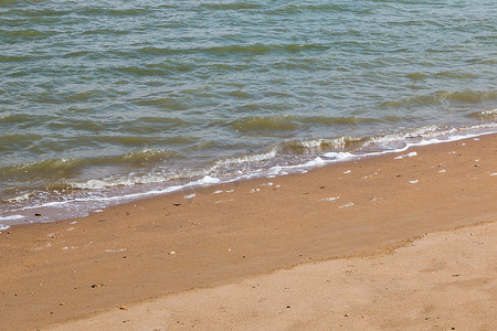 企业海面摄影照片_平静的海面来到沙滩上的海滩