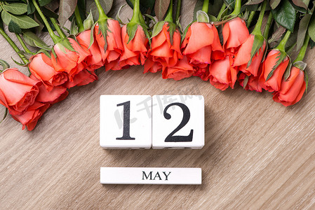 立方体形状日历 5 月 12 日在木桌上与玫瑰