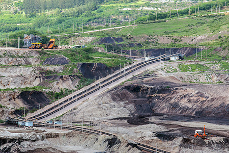 矿用挖掘机摄影照片_大型矿用卡车工作的坑的一部分