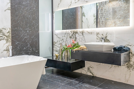 带白色瓷砖墙、大理石地板、白色浴缸和水槽的现代浴室角