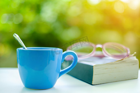 一杯蓝色咖啡，眼镜模糊，书本打开
