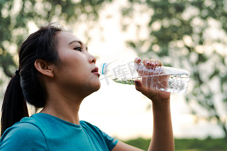 健身亚洲女人跑步后喝水