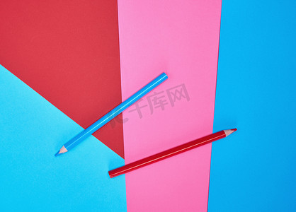在颜色抽象背景的红色和蓝色木铅笔