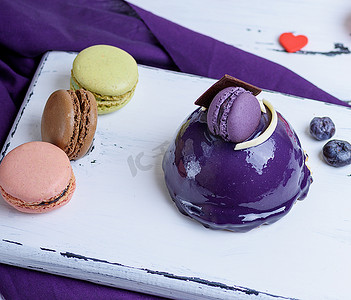 马卡龙背景板摄影照片_淡紫色圆形蛋糕配马卡龙