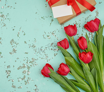 包裹的绿叶摄影照片_一束红色盛开的郁金香与绿叶，包裹的礼物我