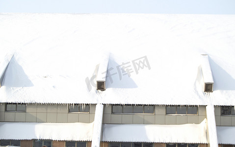 冻货摄影照片_建筑或运动机库的屋顶被雪覆盖，阳光明媚的冬日，室外