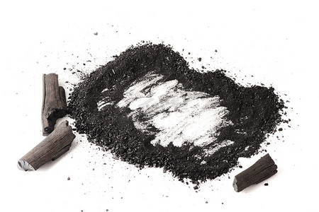 干的摄影照片_白色背景上的木炭和粉末（活性炭）。