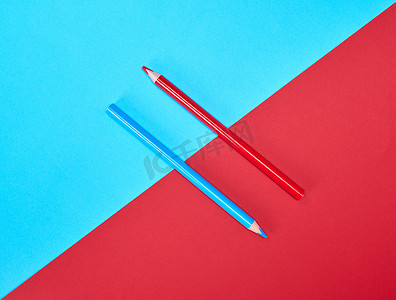 在颜色抽象背景的红色和蓝色木铅笔