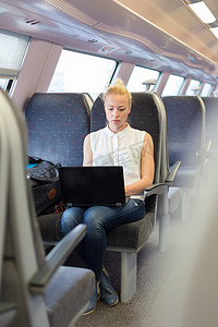 坐火车旅行的女人在笔记本电脑上工作。