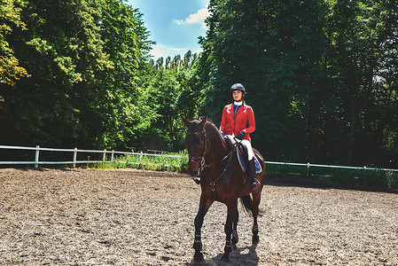 盛装摄影照片_年轻漂亮的骑师女孩准备骑马。