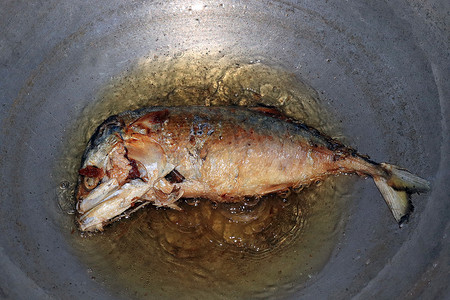 用热沸腾的油在锅里炸鲭鱼，咸鲭鱼油炸食品