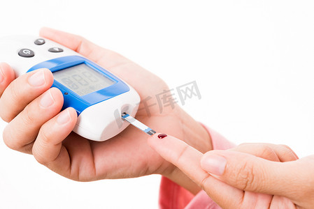 手指摄影照片_妇女用手指上的血液测量血糖测试水平