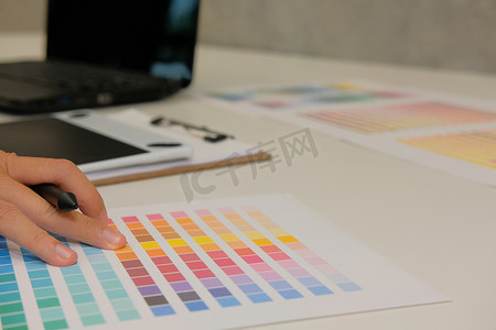 图形室内设计师从样本样本目录调色板指南中选择颜色。