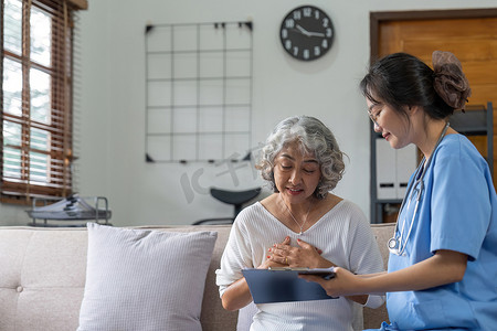 亚洲年轻女护士、辅助生活、家庭护理人员或医生拜访家中老年老人谈论结果跟进清单