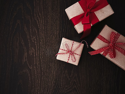 圣诞礼物和传统节日礼物，木质背景的经典圣诞礼盒，用红丝带工艺纸包裹的礼物，复古乡村风格的季节性节日