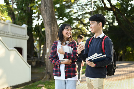 两个友好的大学生课后在大学校园户外散步时互相交谈