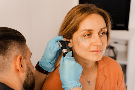用耳镜对女性耳朵进行特写检查。