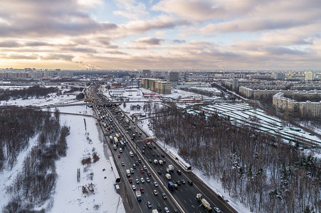 在城市阳光明媚的冬季寒冷的早晨，汽车在直达高速公路上行驶。