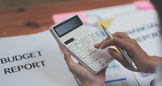 特写女商人使用计算器在办公室的木桌上进行数学财务和商业工作背景、税务、会计、统计和分析研究概念