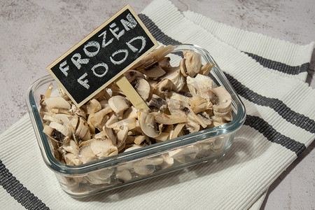 冻货摄影照片_冷冻食品切片蘑菇蘑菇与黑板木标签和文字冷冻食品自制。