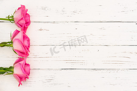 感恩母亲节活动摄影照片_白色木质背景上的浪漫粉红色插花