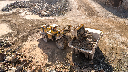 挖掘机和自卸车在采石场采矿