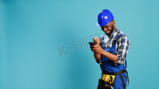 快乐的建筑工人在相机上使用智能手机