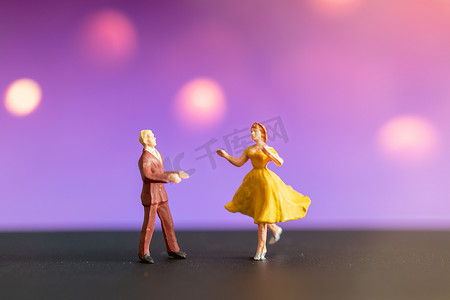 微型人物，色彩缤纷的背景下跳舞的情侣