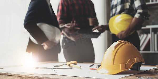 土木工程师团队在现代城市的建筑工地上一起工作，戴着工人头盔安全帽。