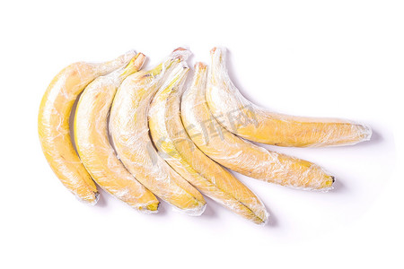 创意易拉宝易拉宝摄影照片_香蕉水果包裹在拉伸包装塑料隔离背景中