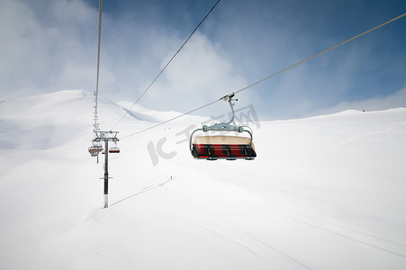 冬季阳光明媚，以雪山为背景，从滑雪胜地空中客运线的外部观看